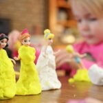 Selective Focus Photography of Three Disney Princesses Figurines on Brown Surface