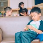 Children enjoying playtime in a comfortable indoor setting with toys and friends.